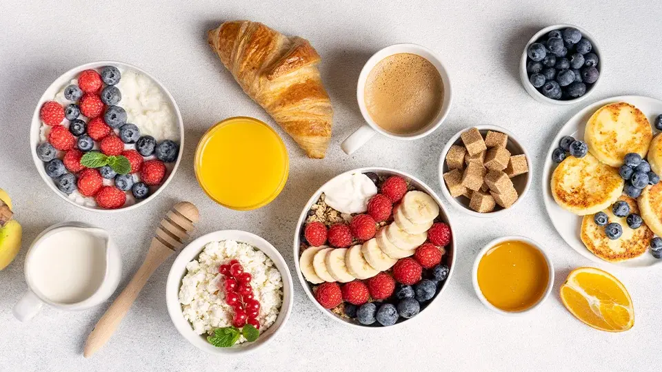 Healthy breakfast spread with yogurt, fruit, and croissants