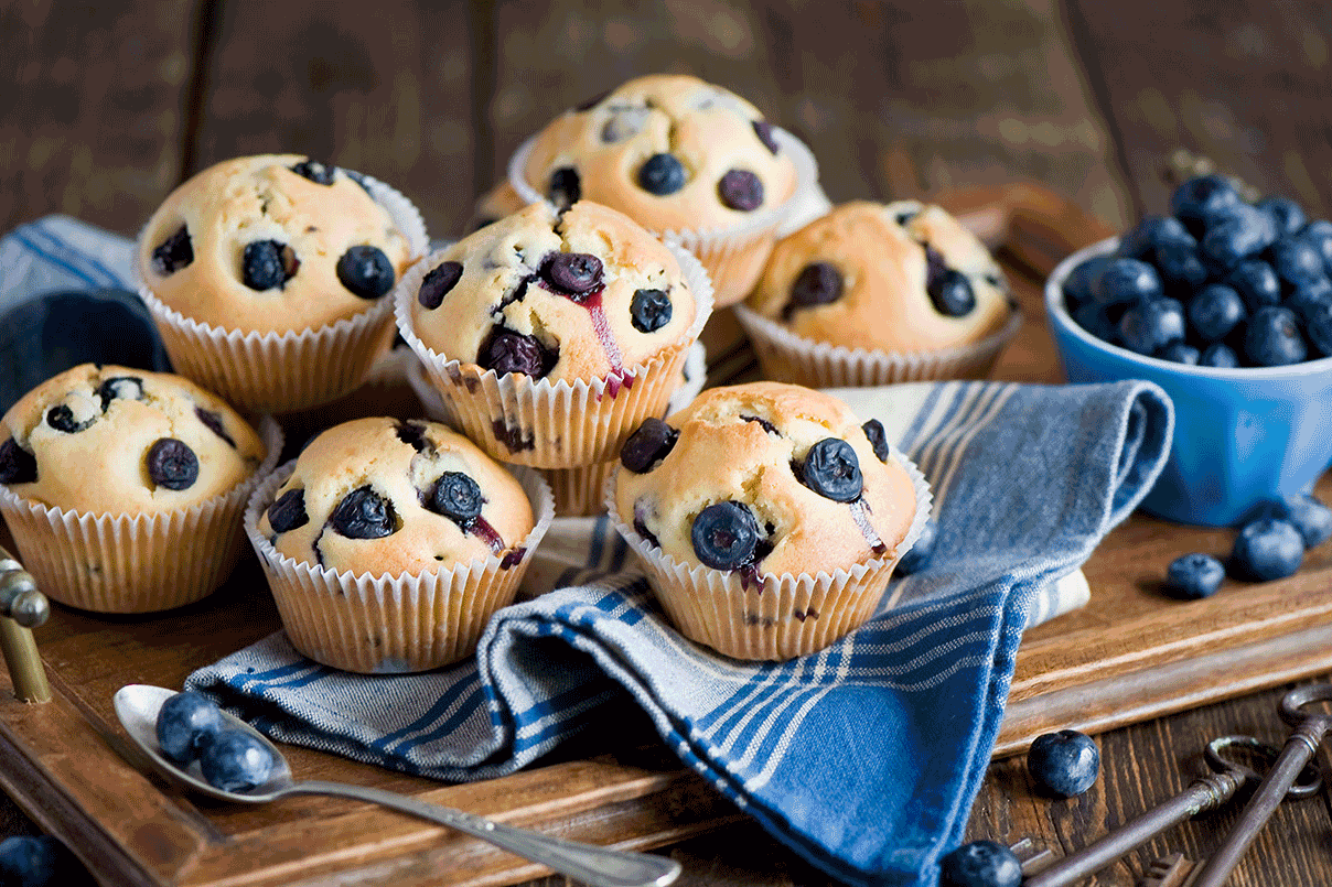 A dozen blueberry muffins with fresh blueberries