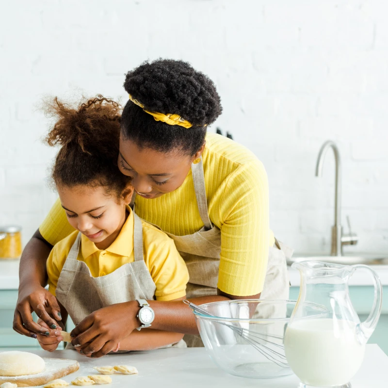 Woman and child baking with pitcher of milk