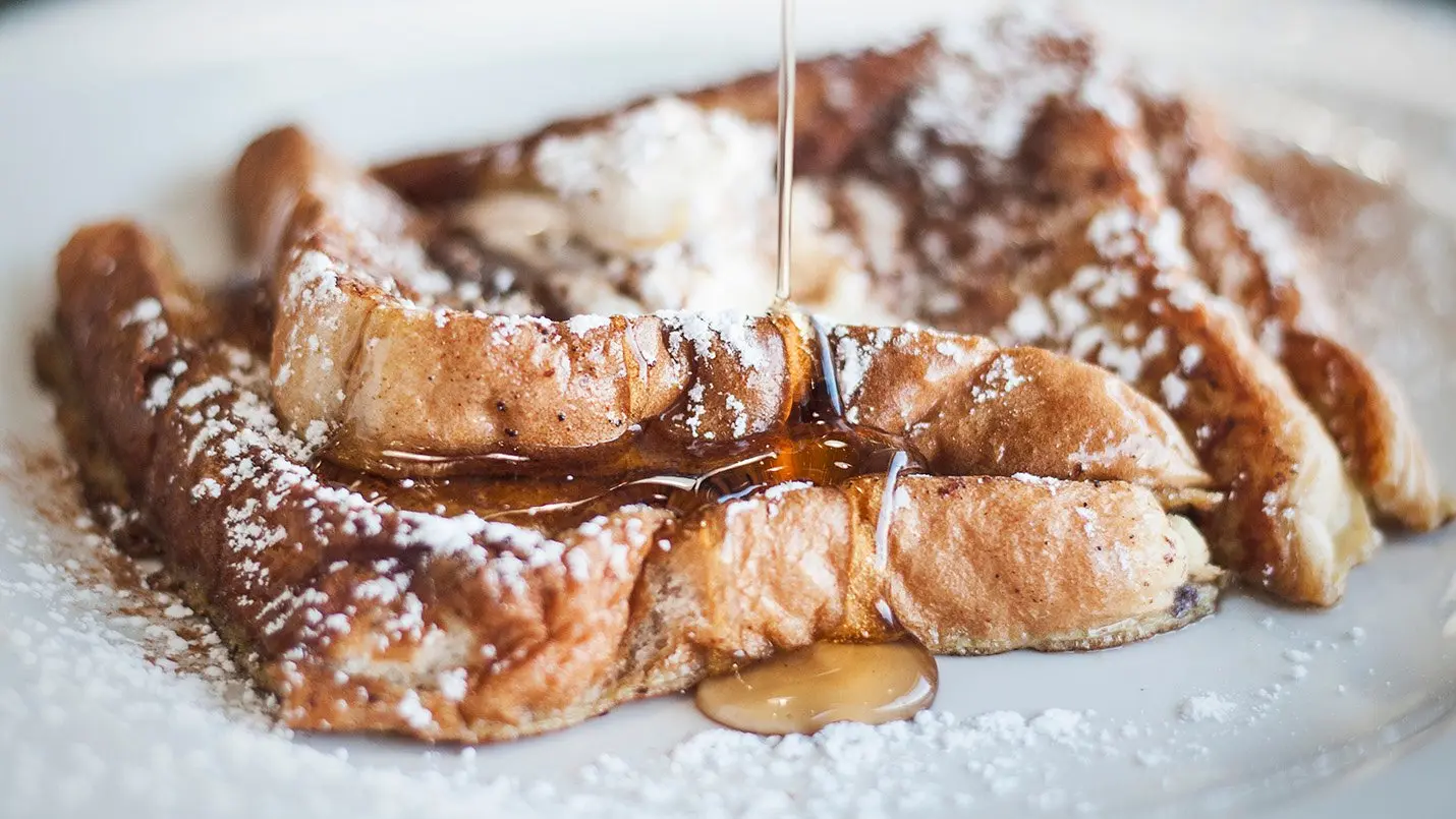 Lactose-free baked french toast with syrup being poured on top
