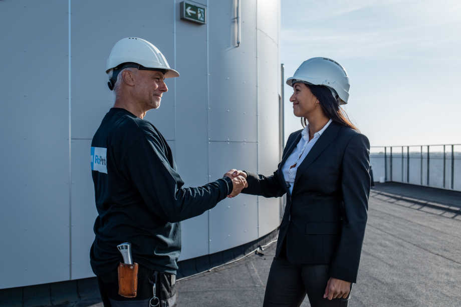 A RoofPro representative shaking hands with a client
