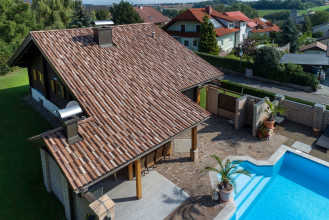 Einfamilienhaus im Sommer mit einem Dach, eingedeckt mit dem Bramac Dachstein Adria