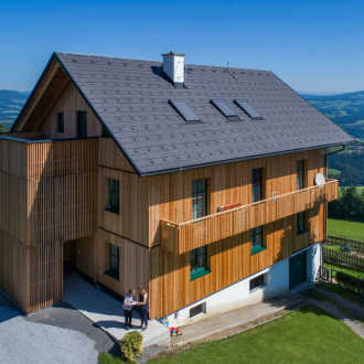 Haus mit verschiedenen Steildachzubehör und Holzfassade in ländlichen Umgebung