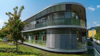 Die moderne Seitenansicht des Salzkammergut-Klinikums Gmunden mit eleganter, moderner Fassade und Flachdach.