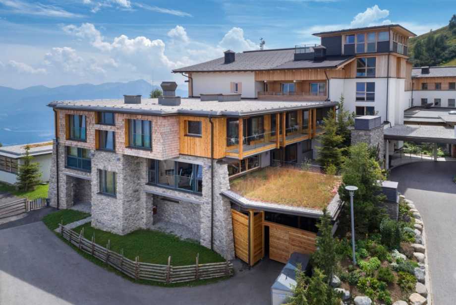 Mountain Resort Feuerberg mit verschiedenen Systemlösungen von BMI Villas für die Flachdächer sowie Gründächer, eleganter Steinmauer und Holzverkleidung