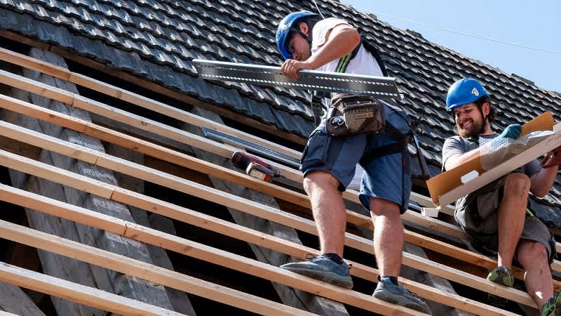 Dachdecker mit der entsprechenden Schutzausrüstung verbauen die verschiedenen Dachzubehöre von BMI Österreich 