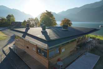 Strandbad mit Seeblick und grauen DichtDach Contur sowie einer modernen Holzfassade