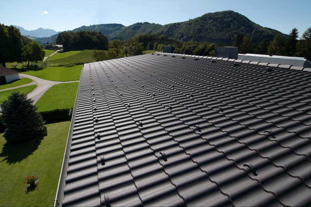 BMI Bramac 7° DachSystem in der Farbe brilliantschwarz gibt Haus in ländlicher Umgebung einen modernen Anstrich 