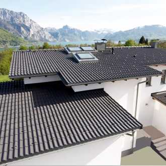 7 Grad Dach eines Einfamilienhauses mit weißer Fassade, welches einen Blick auf einen See und Berge erlaubt