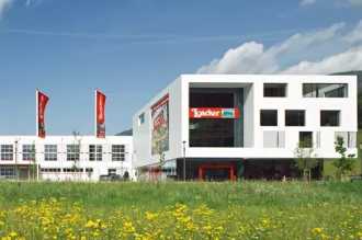 Unternehmensgebäude von Loacker-Werk in Osttirol mit weißer Fassade und Flachdach 
