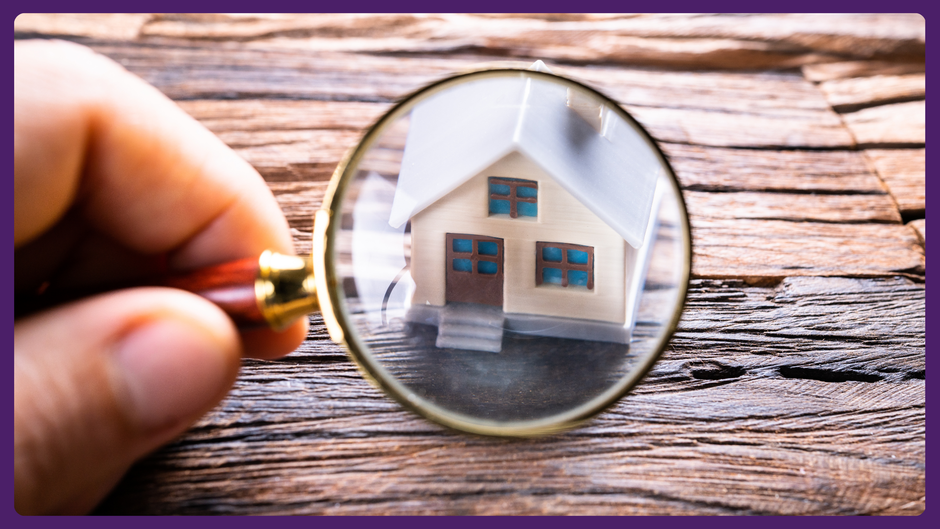 A magnifying glass focusing on a model house.