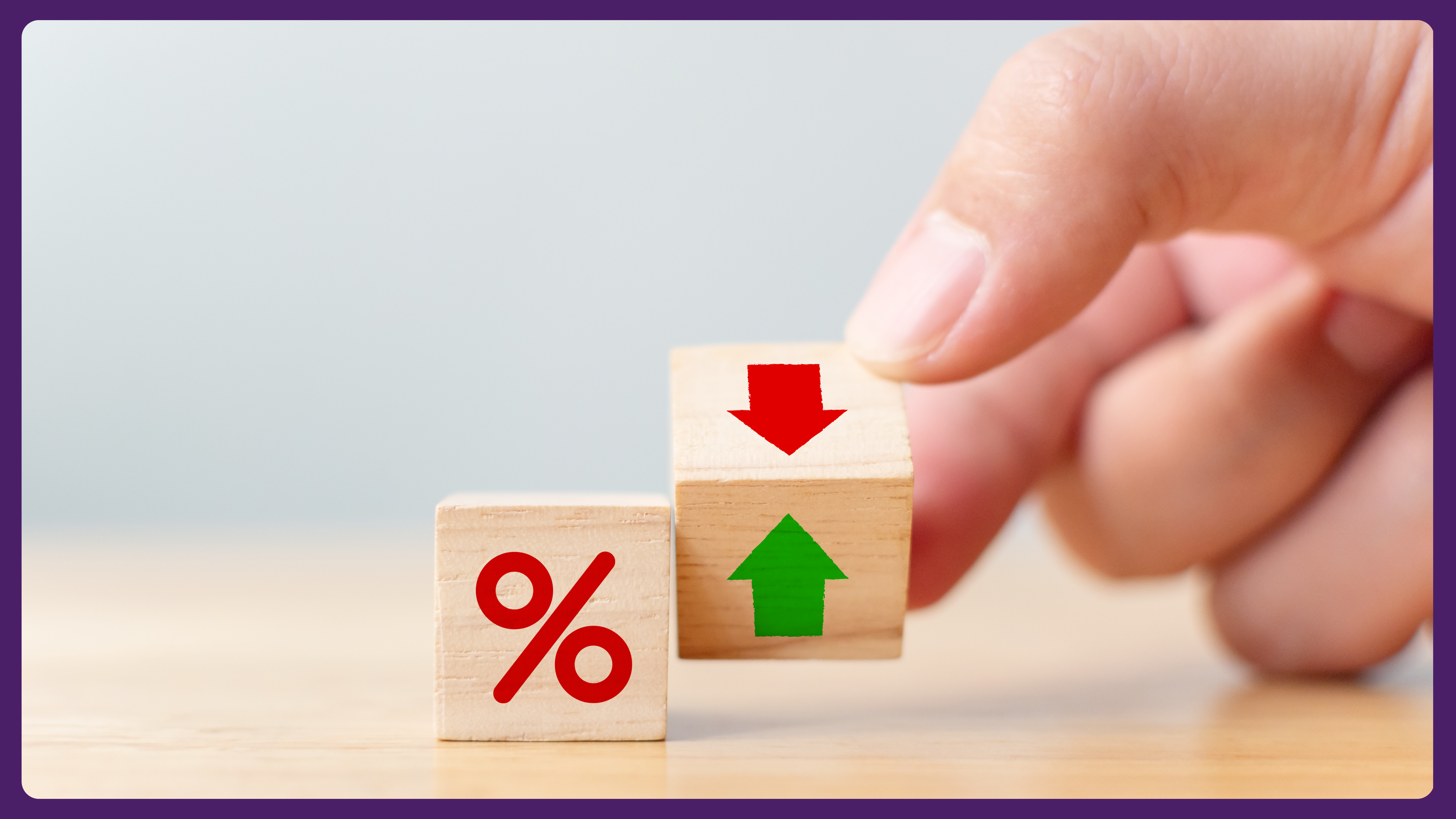 A hand holding a wooden block with up and down arrows beside a percentage symbol.