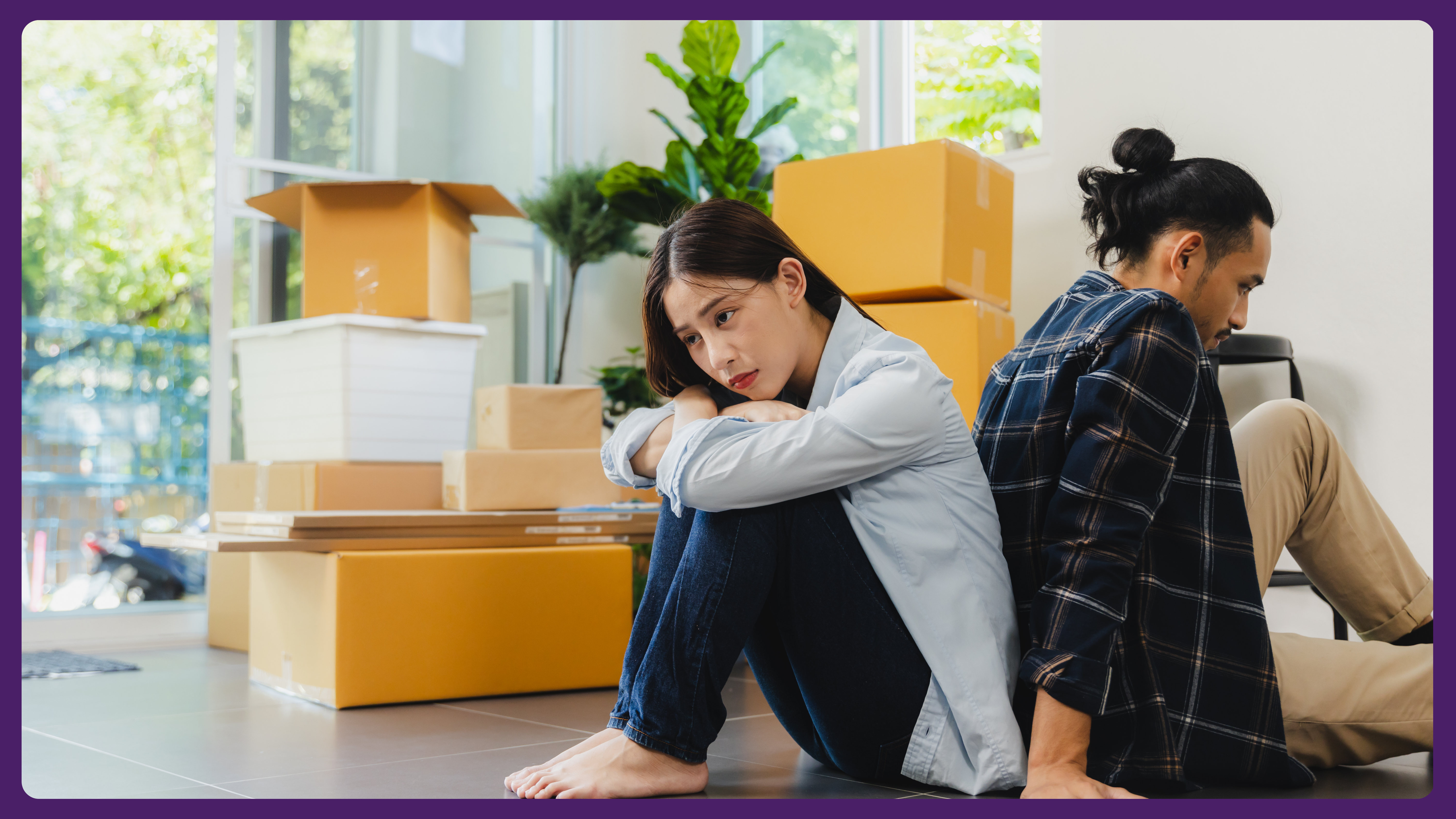 A couple sitting apart in a home surrounded by moving boxes.