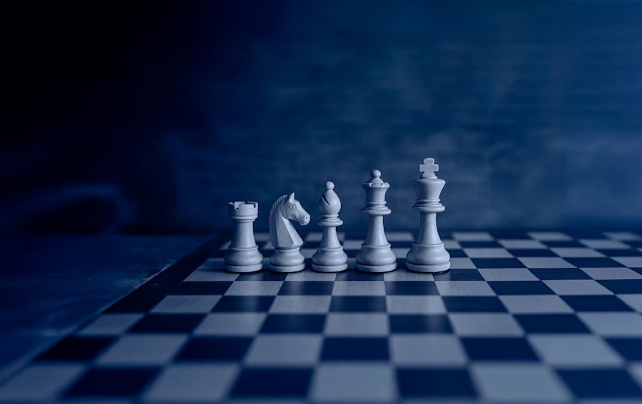 Pièces d'échecs blanches alignées sur un échiquier bleu et blanc, avec une ambiance sombre et mystérieuse.