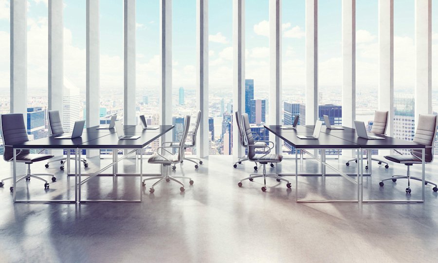 Moderne vergaderruimte met bureaus en laptops in wolkenkrabber, met panoramisch uitzicht op de skyline van de stad.