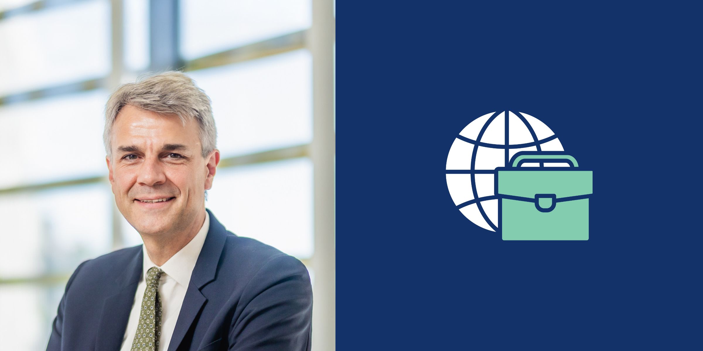 Jérôme Vander Bruggen en costume d'affaires souriant à côté d'un logo représentant un globe et une mallette verte sur fond bleu.