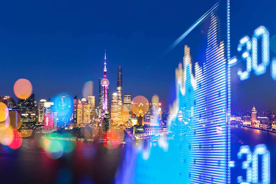 Nachtelijke skyline van Shanghai met de Oriental Pearl Tower, verlichte wolkenkrabbers en een digitale beursgrafieklijn in blauw.