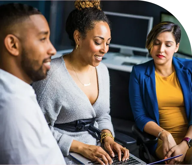 Woman on laptop sitting with colleagues