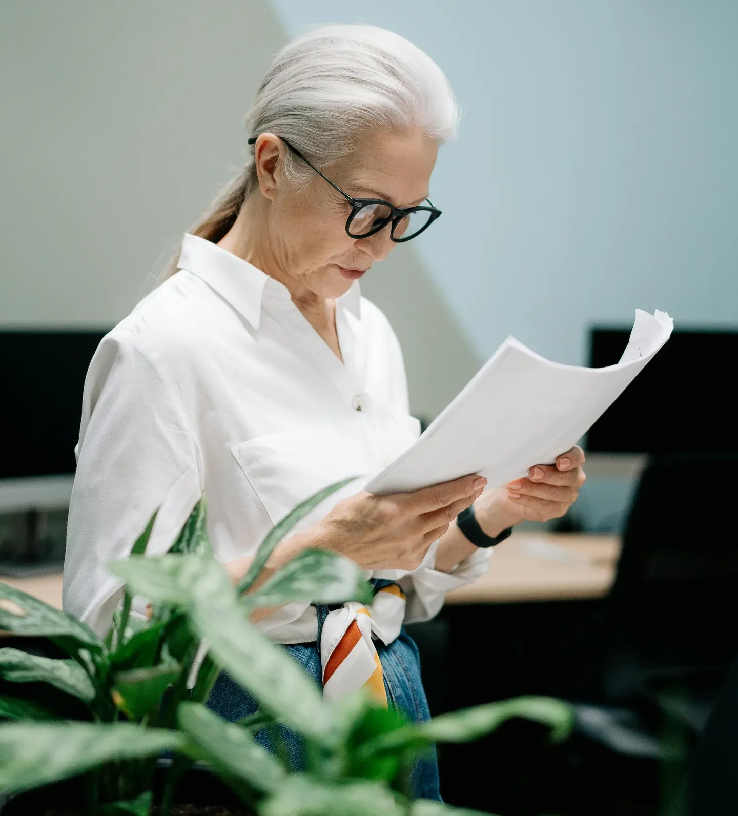 woman with white hair reading document