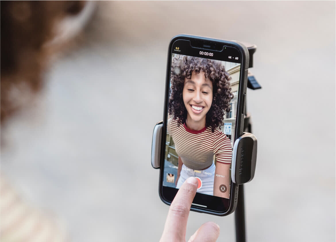Woman with curly hair films herself using tripod. Text overlay reads Work 2x Faster with Later