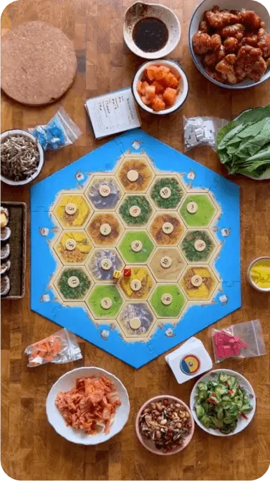 Board game with snacks surrounding the board including bibigo dumplings