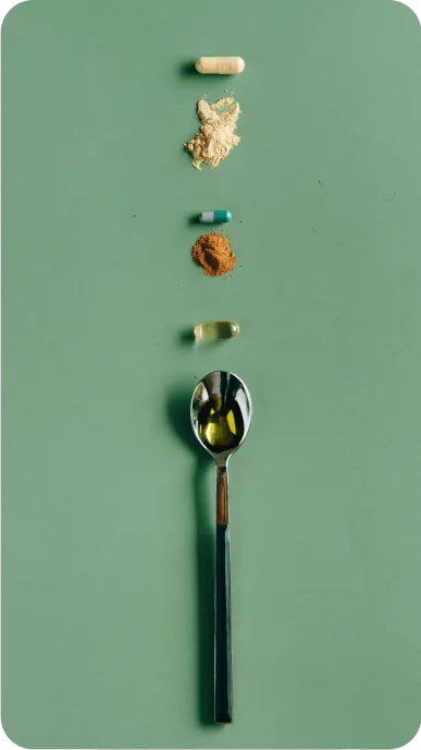 Spoon and pills which represent sleep aids on a green background