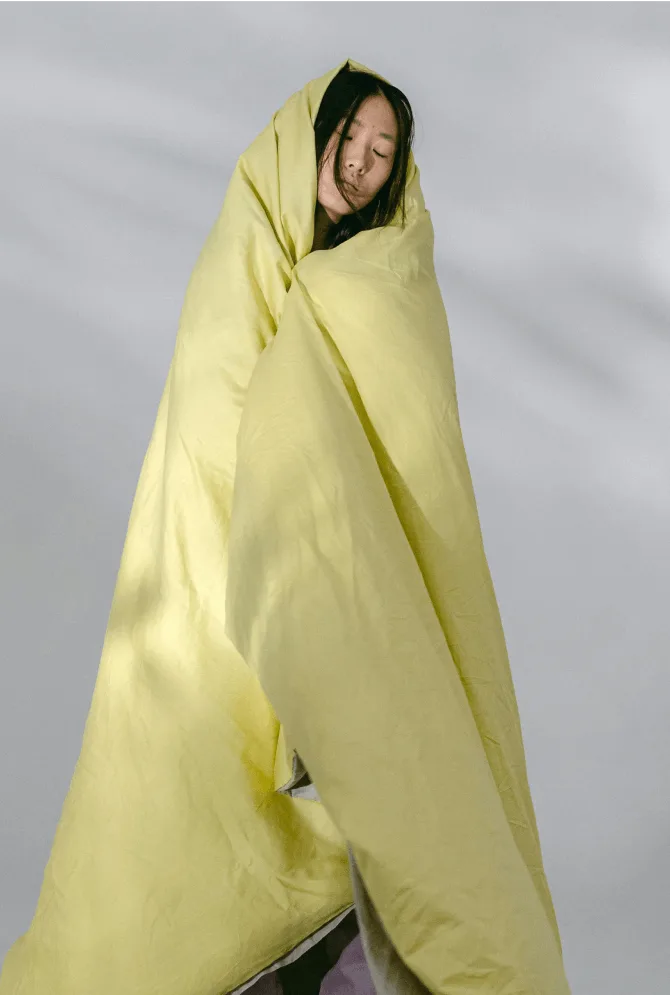 Woman wrapped in yellow duvet next to key campaign results