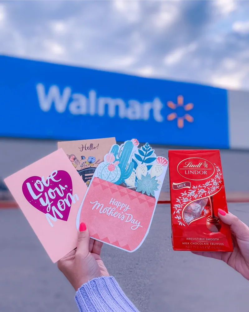Child holds American Greetings cards and Lindt chocolates outside of a Walmart