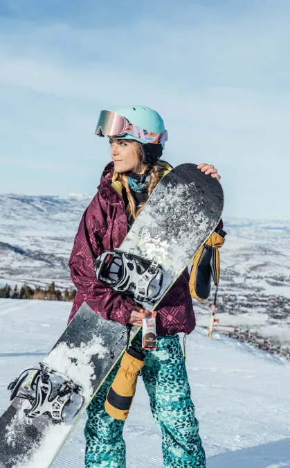 Woman eating packaged snack bar while snowboarding next to key campaign statistics