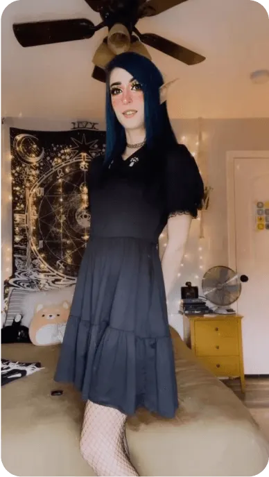 Creator with black dress from hot topic and elf ears poses in bedroom