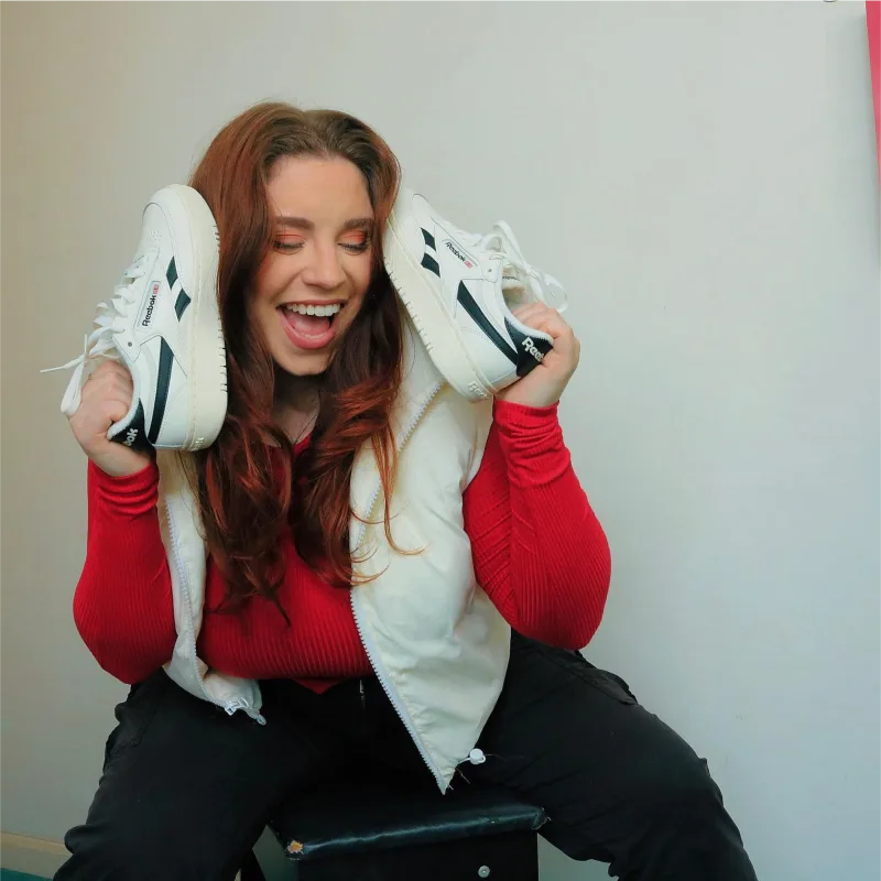 Creator holds Reebok shoes on both sides of her face in Instagram post