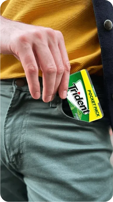 Close up of a man putting a Trident pocket pack into his pocket