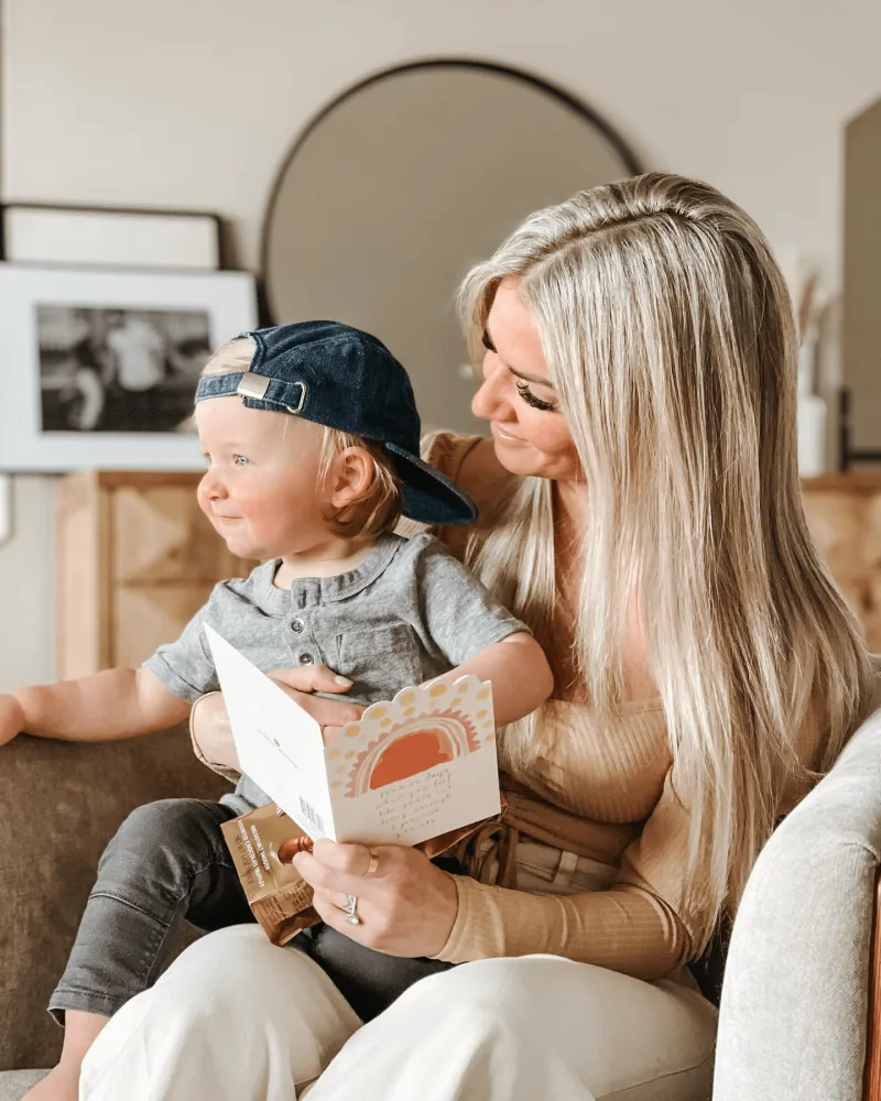 Influencer poses with child while reading a card