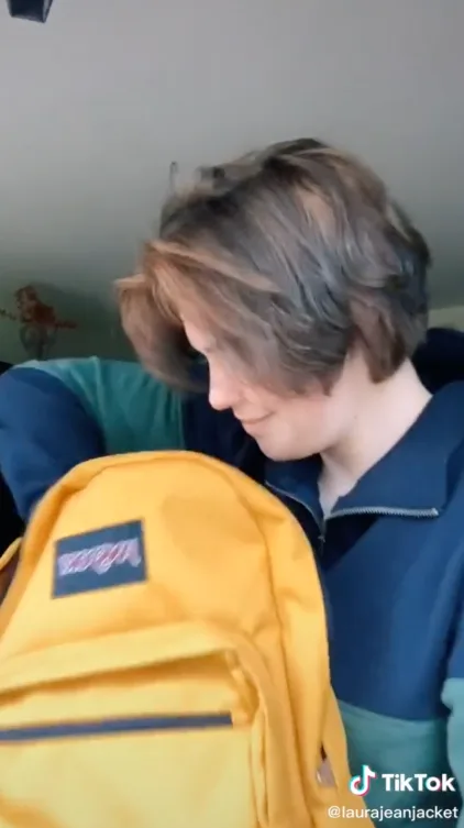 Still of TikTok from creator Lou Jean Jacket with a yellow JanSport backpack