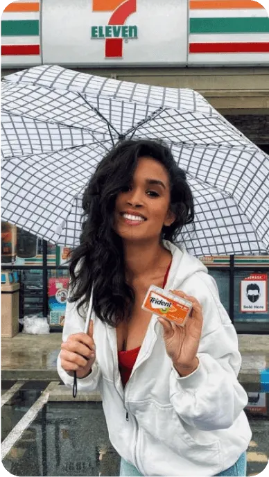Creator with white umbrella poses with Trident outside of 7 11 store