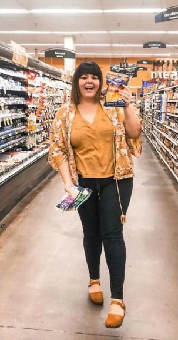 Woman in grocery store posing with Kraft cheeses