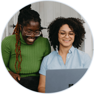 2 people working at a marketing agency review content on their laptop together