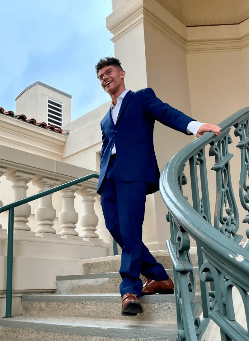 Instagram post of young man in blue tuxedo walking downstairs outdoors