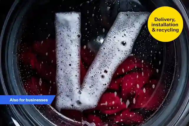 Verkkokauppa.com V-logo inside a washing machine drum with red clothes and soap suds. Delivery, installation and recycling.