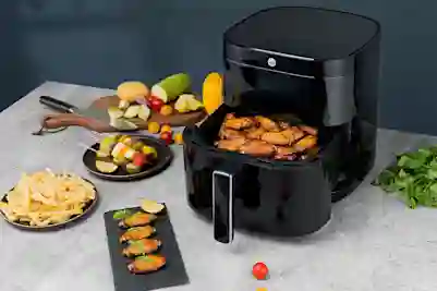 Wingsejä asetettuna airfryerin koriin. Ympärillä muita ruoka-aineita.