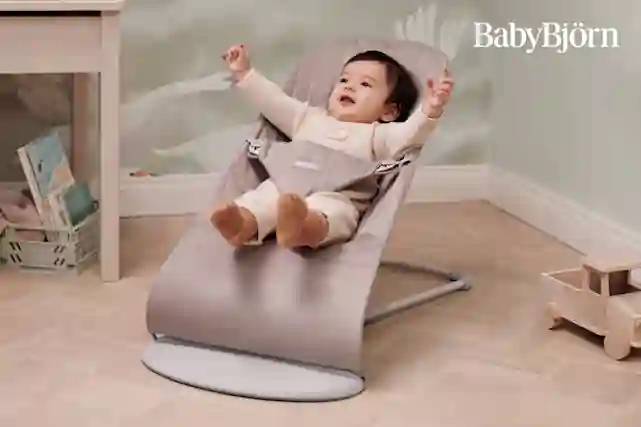 Lapsi liikehtii BabyBjörn sitterissä lastenhuoneessa.