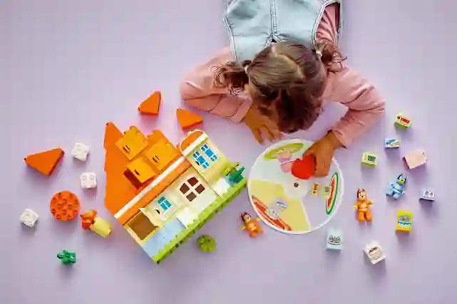 Lapsi leikkii LEGO DUPLO Bluey 10459 Blueyn perheen talo ja muistipeli -legolla.