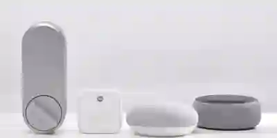Smart home devices: Yale smart lock, white hub, white and gray smart speaker on a gray background.