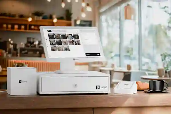 Kahvilan tiskillä kassajärjestelmä, johon sisältyy maksupääte, kassalipas, kuittitulostin ja iso näyttö.