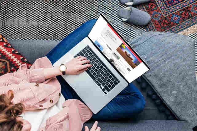 Nainen istuu sohvalla ja selaa Verkkokauppa.com valikoimaa tietokoneellaan. Tutustu tietokoneisiin!
