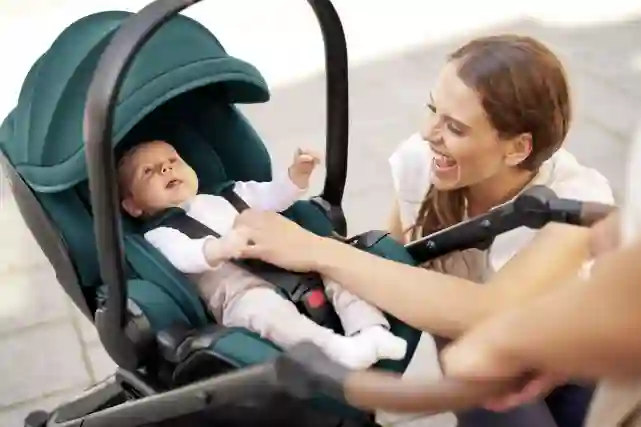 Nainen nauraa vauvalle joka makaa rattaisiin jokellellen. Tutustu Verkkokauppa.comin lastentarvikkeisiin!