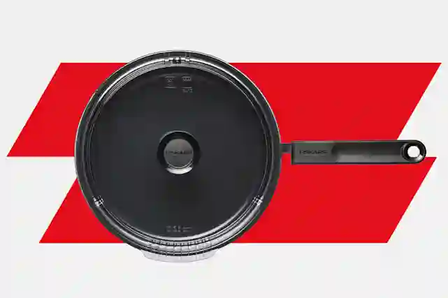 Fiskars Functional Form -paistokasari kannella punaisella taustalla.