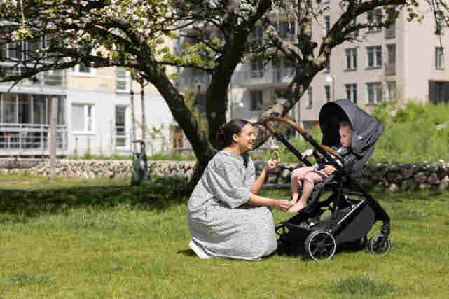 Nainen on lapsen kanssa puistossa. Lapsi istuu rattaissa. Tutustu Verkkokauppa.comin lastenvaunuihin ja rattaisiin!