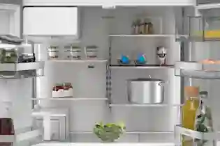 Innehållet i ett Siemens-kylskåp: hyllor, kastrull, glasburkar, juice, salladssskål och olika livsmedel.