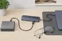 Työpöydällä telakka kiinni kannettavassa tietokoneessa ja telakassa on kiinni lisätarvike.